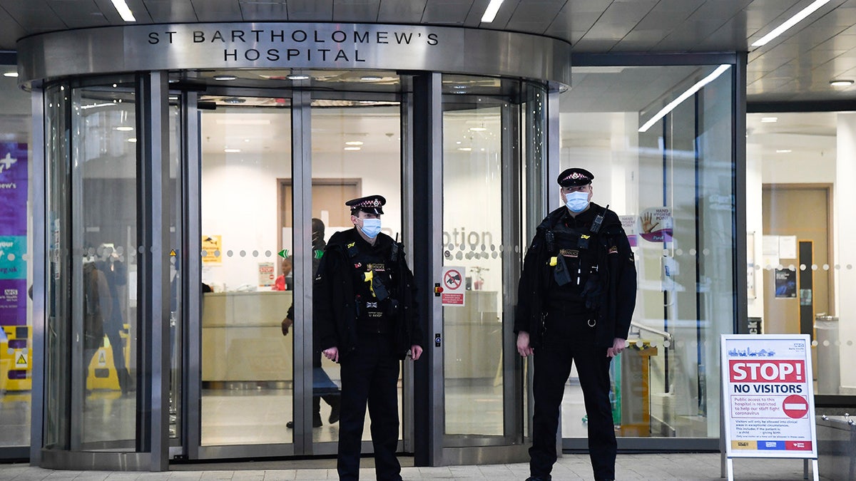 Police officers stand outside the main entrance of St Bartholomew's Hospital where Britain's Prince Philip is being treated in London.