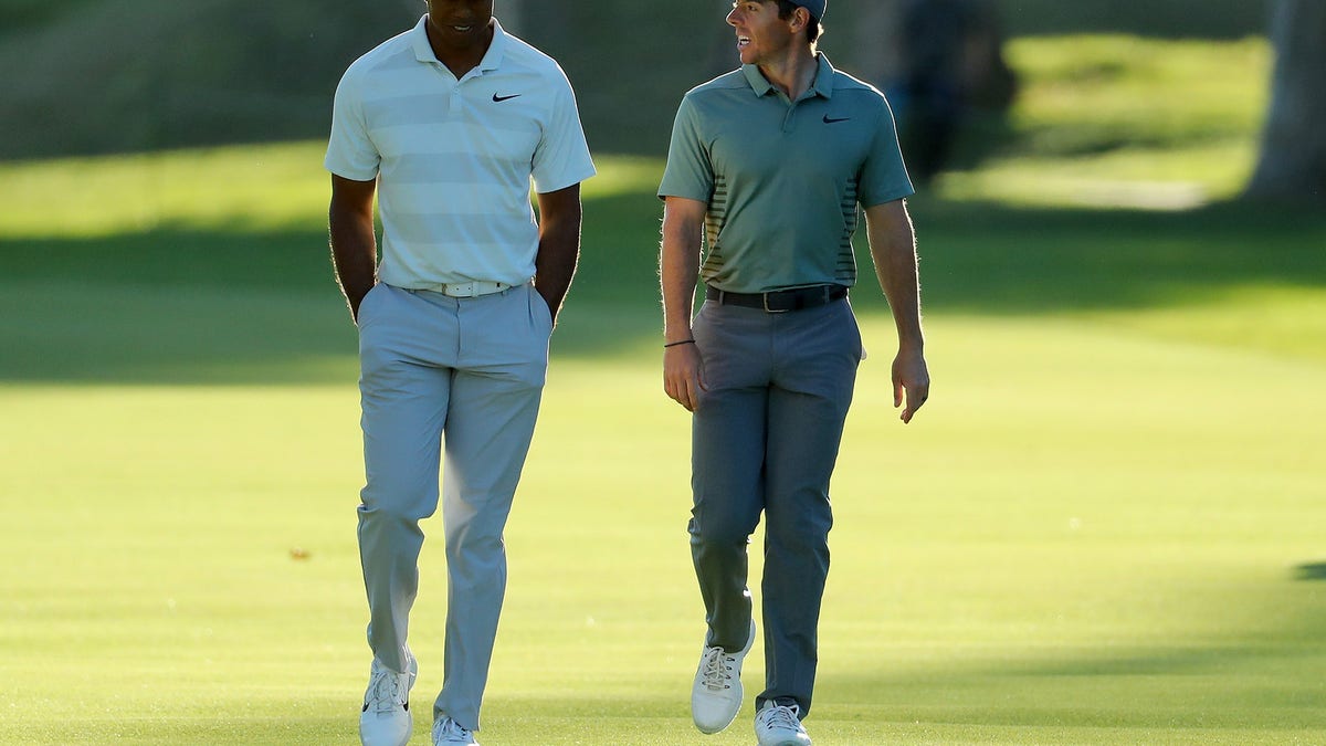 Tiger Woods and Rory McIlroy of Northern Ireland walk across the 17th hole during the second round of the Genesis Open at Riviera Country Club on February 16, 2018 in Pacific Palisades, California.