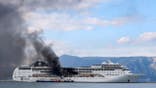 Firefighters on vessels try to extinguish a fire on a cruise ship at the port of Corfu, northwestern Greece, Friday, March 12, 2021. A fire broke out on the cruise ship docked in the port of Corfu as the 51 crew members on board were in good health, the coast guard said. The cause of the fire was not immediately known. (Stamatis Katopodis/InTime News via AP)