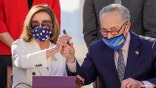 House Speaker Nancy Pelosi of Calif., and Senate Majority Leader Chuck Schumer of N.Y., pose after signing the $1.9 trillion COVID-19 relief bill during an enrollment ceremony on Capitol Hill, Wednesday, March 10, 2021, in Washington. (AP Photo/Alex Brandon)