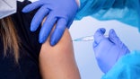 FILE - In this March 2, 2021, file photo, a police officer receives an injection with AstraZeneca's COVID-19 vaccine in Munich, Germany. After saying last week they would continue with the vaccine, German officials said Monday, March 15, they would suspend its use after new reports of problems, based on the advice from its medicines regulator. (Sven Hoppe/dpa via AP, File)