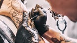 Tattoo artist making a tattoo on a shoulder