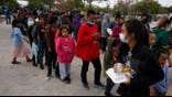 Central American migrants who managed to cross illegally into the U.S. in order to seek asylum, get a meal from a charitable organization at a park, in Reynosa, Mexico, Friday, March 26, 2021, after they were sent back to Mexico by U.S. border authorities. The migrants claimed that they were expelled back to Mexico in the middle of the night two days ago without any legal proceedings. (AP Photo/Dario Lopez-MIlls)