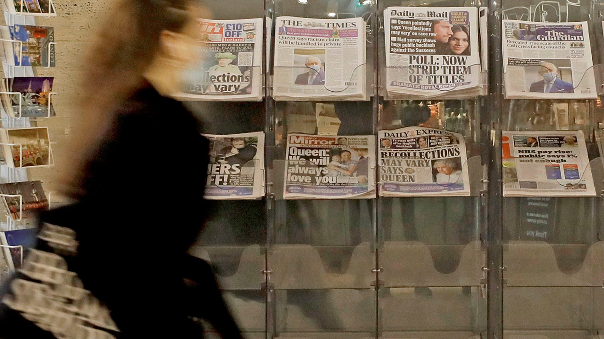 A pedestrian passes newspapers on display with front pages featuring images of members of the royal family, outside a shop in London, Wednesday, March 10, 2021. In countries with historic ties to Britain, allegations by Prince Harry and Meghan about racism within the royal family have raised questions about whether those nations want to be closely connected to Britain anymore after the couple's interview with Oprah Winfrey. (AP Photo/Kirsty Wigglesworth)