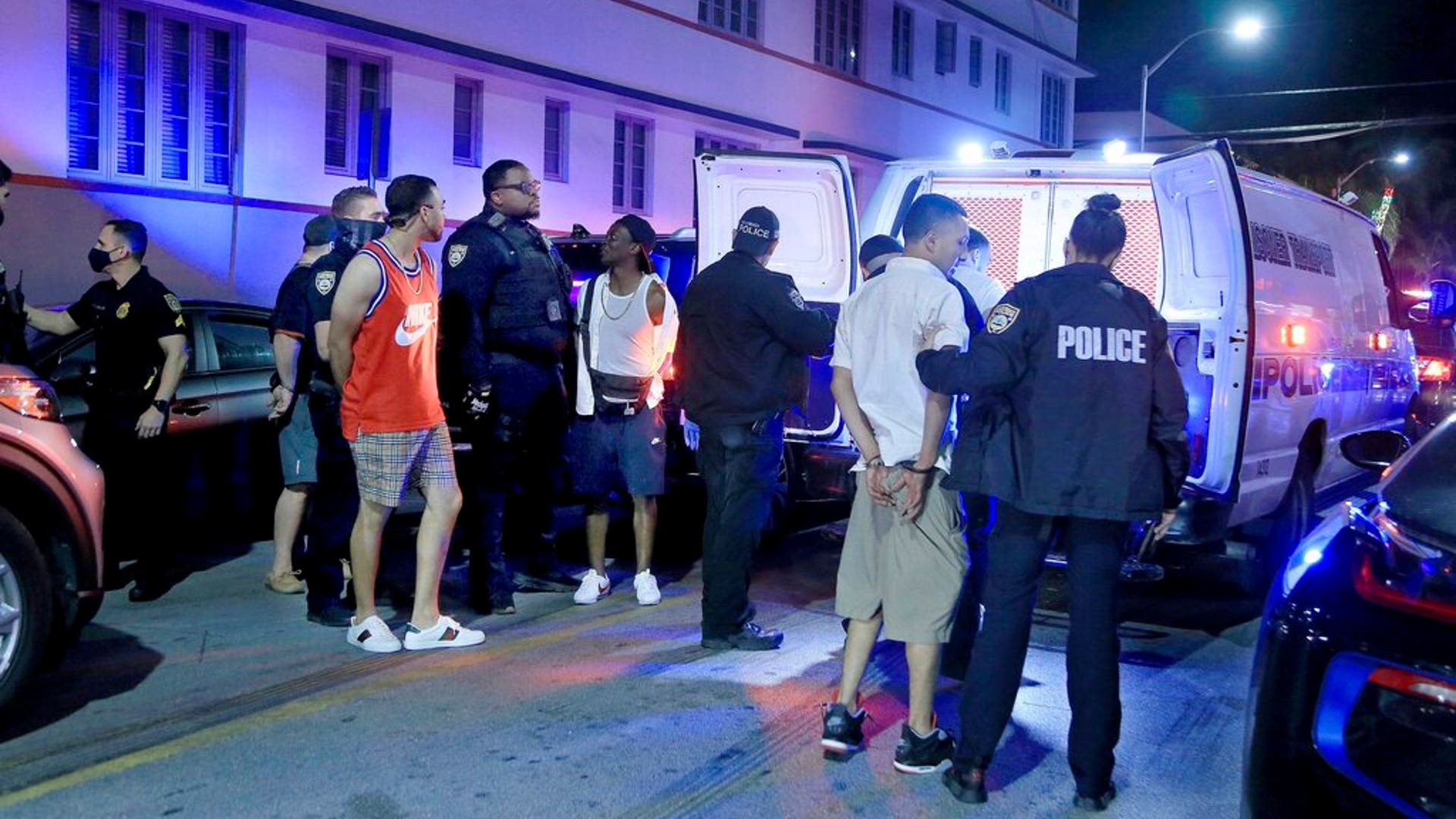 City of Miami Beach police officers arrest several males on Ocean Drive and 10th Street as spring break has officially begun Saturday, Feb. 20, 2021, in Miami Beach, Florida. Miami Beach officials are imposing an emergency 8 p.m.-6 a.m. curfew effective immediately, saying large, out-of-control spring break crowds crammed the beaches, trashed some restaurant properties and brawled in the streets. Tourists and hotel guests are being told to stay indoors during the curfew hours. (Pedro Portal/Miami Herald via AP)