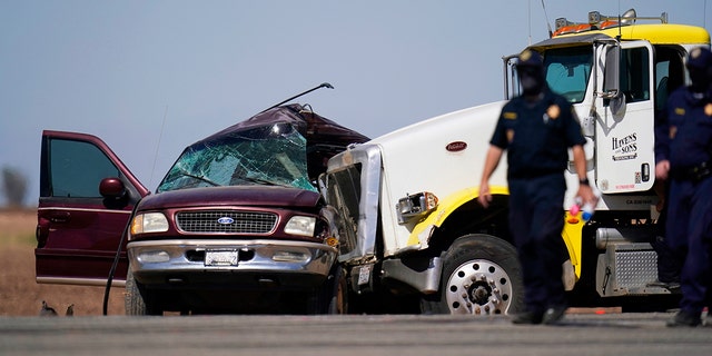 Law enforcement officers are working at the scene of a fatal crash in Holtville, California, on Tuesday, March 2, 2021. Authorities say a semi-truck crashed into an SUV carrying 25 people on a highway in Southern California, killing at least 13 people death.  (AP Photo / Gregory Bull)