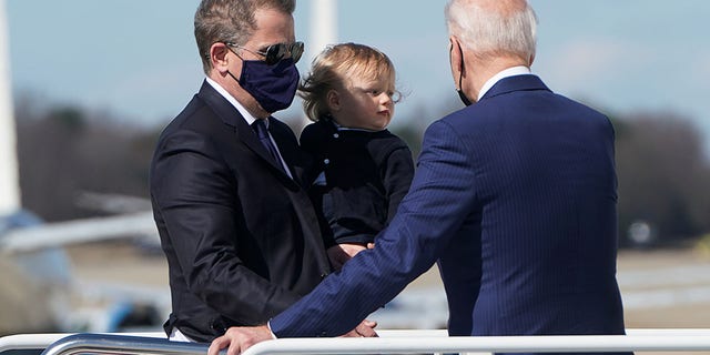 FILE - President Joe Biden turned to help his son Hunter Biden and grandson Beau as they boarded Air Force One with strong winds as they left Washington for a trip to Wiilmington, Delaware at Joint Base Andrews, Maryland, US, March 26, 2021. 