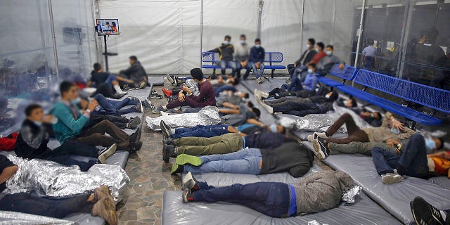 Young children lie inside a pod at the Donna Department of Homeland Security holding facility, the main detention center for unaccompanied children in the Rio Grande Valley run by U.S. Customs and Border Protection, in Donna, Texas, Tuesday, March 30, 2021.