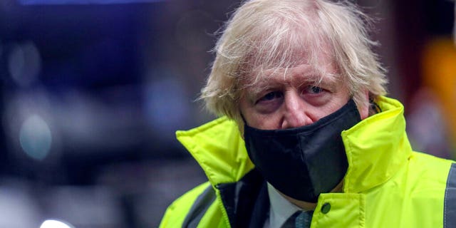 Britain's Prime Minister Boris Johnson visits the National Express depot in Coventry, central England, Monday March 15, 2021. (Steve Parsons/Pool via AP)