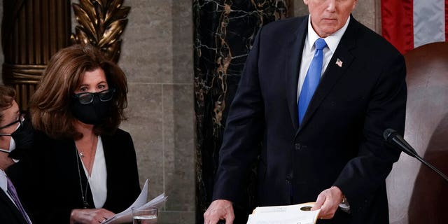 In this Jan. 6, 2021, photo, Senate Parliamentarian Elizabeth MacDonough, second from left, works beside Vice President Mike Pence during the certification of Electoral College ballots in the presidential election, in the House chamber at the Capitol in Washington. Shortly afterward, the Capitol was stormed by rioters determined to disrupt the certification. MacDonough has guided the Senate through two impeachment trials, vexed Democrats and Republicans alike with parliamentary opinions and helped rescue Electoral College certificates from a pro-Trump mob ransacking the Capitol. (AP Photo/J. Scott Applewhite)