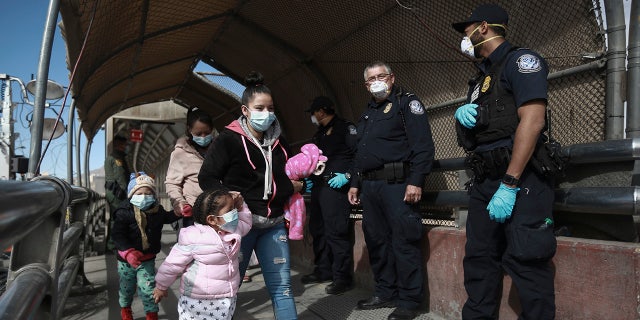 A migrant family crosses the border into El Paso, Texas, in Ciudad Juarez, Mexico, Friday, Feb. 26, 2021. (AP Photo/Christian Chavez)