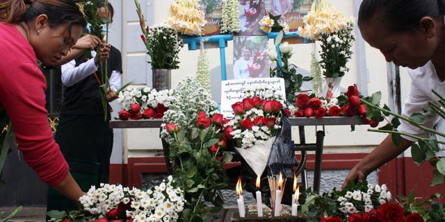 People offer flowers as a tribute to a teacher who died in a protest on Feb 28, during a memorial service in Yangon, Burma, Monday, March 1, 2021. (AP Photo)