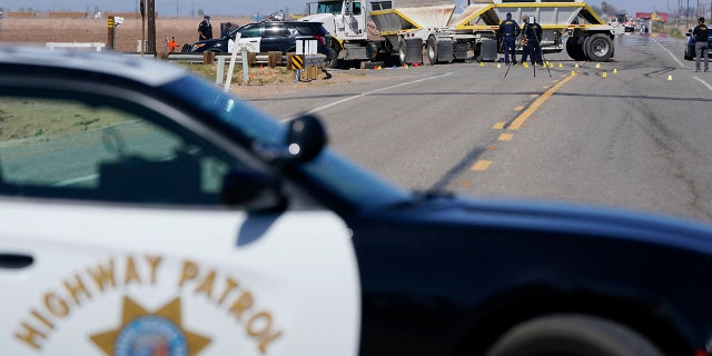 Law enforcement officers work at the scene of a deadly crash in Holtville, Calif., on Tuesday, March 2, 2021. (AP Photo/Gregory Bull)