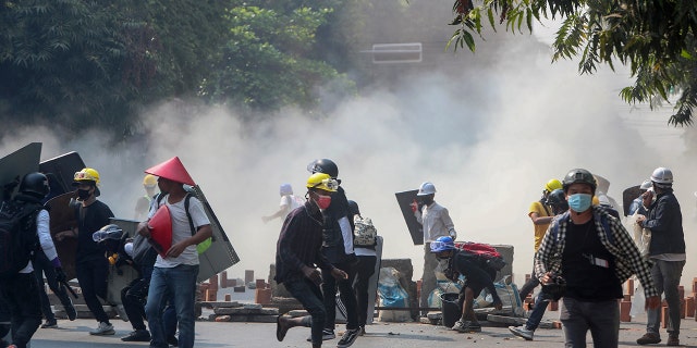Anti-coup protesters run from teargas and charging riot police and soldiers in Mandalay, Myanmar, Wednesday, March 3, 2021. Demonstrators in Myanmar took to the streets again on Wednesday to protest last month's seizure of power by the military. (AP Photo)
