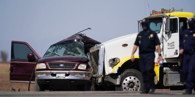 FILE - In this Tuesday, March 2, 2021, file photo, law enforcement officers work at the scene of a deadly crash in Holtville, Calif. Nine migrants in an SUV packed with 25 people that drove through an opening in a border wall suffered major injuries after their vehicle slammed into a tractor-trailer and killed 13 others inside, the California Highway Patrol said Thursday, March 4, 2021. (AP Photo/Gregory Bull, File)