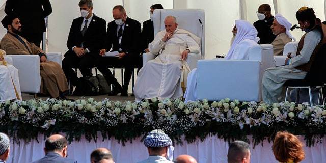 Pope Francis, center, listens during an interreligious meeting near the archaeological site of Ur near Nasiriyah, Iraq, Saturday, March 6, 2021. Pope Francis and Iraq's top Shiite cleric delivered a powerful message of peaceful coexistence Saturday, urging Muslims in the war-weary Arab nation to embrace Iraq’s long-beleaguered Christian minority during an historic meeting in the holy city of Najaf. (AP Photo/Nabil al-Jourani)