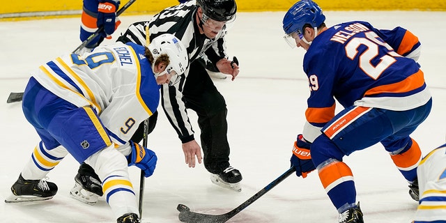 New York Islanders center Brock Nelson (29) wins a face-off against Buffalo Sabres center Jack Eichel (9) during the second period an NHL hockey game, Sunday, March 7, 2021, in Uniondale, N.Y. (AP Photo/John Minchillo)