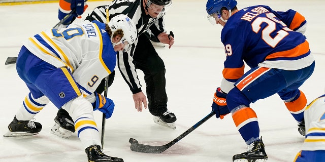 New York Islanders center Brock Nelson (29) wins a face-off against Buffalo Sabres center Jack Eichel (9) during the second period an NHL hockey game, Sunday, March 7, 2021, in Uniondale, N.Y. (AP Photo/John Minchillo)
