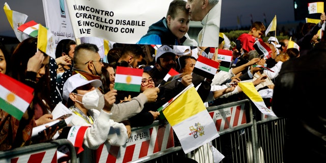 Iraqi Christians say goodbye to Pope Francis after an open air Mass at a stadium in Irbil, Iraq, Sunday, March 7, 2021. Thousands of people filled the sports stadium in the northern city of Irbil for Pope Francis' final event in his visit to Iraq: an open-air Mass featuring a statue of the Virgin Mary that was restored after Islamic militants chopped of the head and hands. (AP Photo/Hadi Mizban)