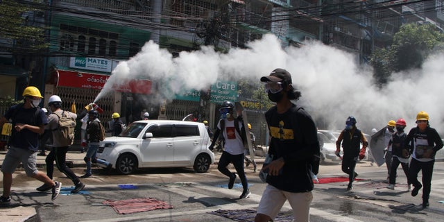 An anti-coup protester discharges a fire extinguisher to counter the impact of the tear gas fired by police during a demonstration in Yangon, Burma, Monday, March 8, 2021. Large protests have occurred daily across many cities and towns in Burma. (AP Photo)