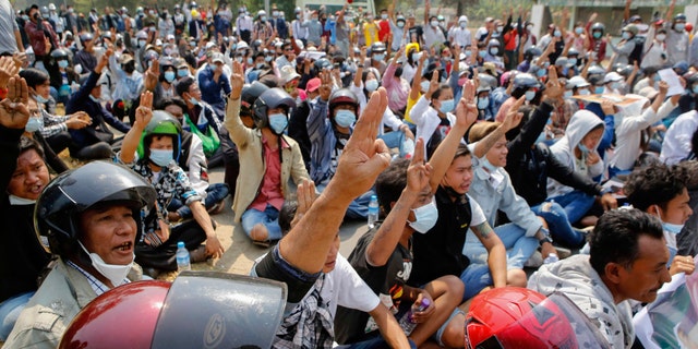 Anti-coup protesters flash a three-fingered sign of resistance during a demonstration in Naypyitaw, Burma, Monday, March 8, 2021. The escalation of violence in Burma as authorities crackdown on protests against the Feb. 1 coup is raising pressure for more sanctions against the junta, even as countries struggle over how to best sway military leaders inured to global condemnation. (AP Photo)