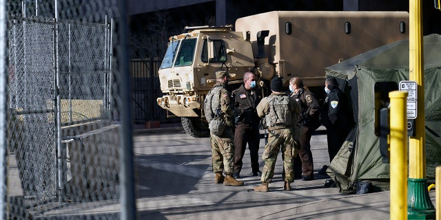 Deputies and National Guard soldiers converse, Tuesday, March 9, 2021, in Minneapolis where the trial for former Minneapolis police officer Derek Chauvin continues with jury selection. Chauvin is charged with murder in the death of George Floyd during an arrest last may in Minneapolis. AP Photo/Jim Mone)