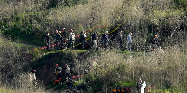 In this Jan. 27, 2020, file photo, investigators work the scene of a helicopter crash that killed former NBA basketball player Kobe Bryant in Calabasas, Calif.  (AP Photo/Mark J. Terrill, File)