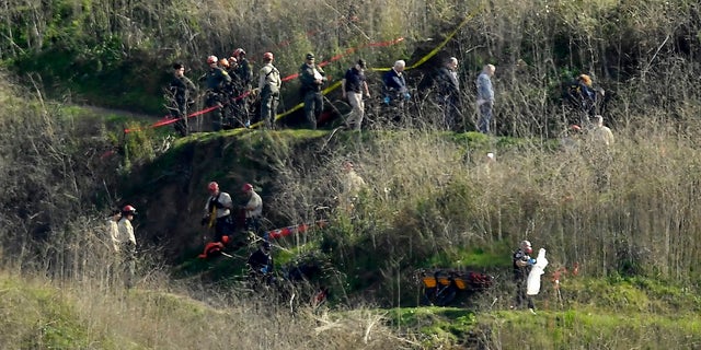 In this Jan. 27, 2020, file photo, investigators work the scene of a helicopter crash that killed former NBA basketball player Kobe Bryant in Calabasas, Calif. (AP Photo/Mark J. Terrill, File)