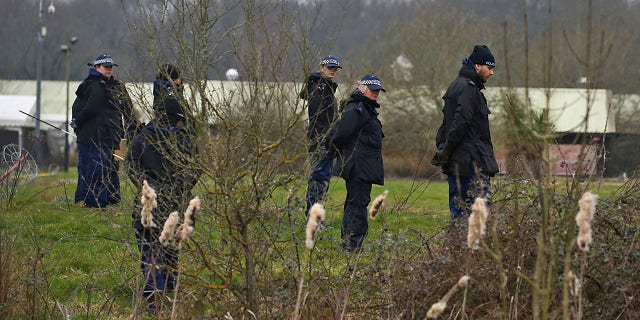 Metropolitan Police officers search land near Great Chart Golf and Lesiure in connection with Sarah Everard's disappearance in Ashford, England on Wednesday March 10, 2021. UK Metropolitan Police say officer has been arrested in connection with the case of a woman who went missing in London last week. (Gareth Fuller / PA via AP)