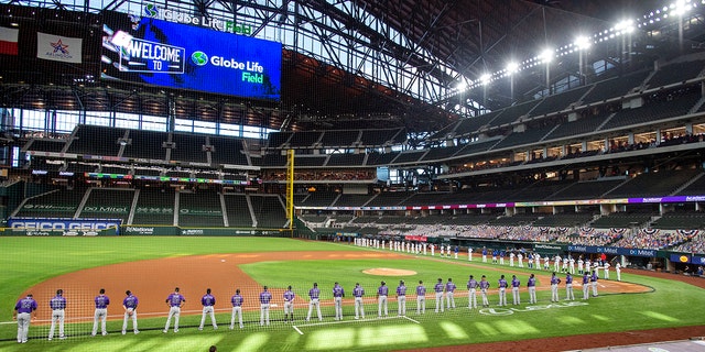 DOSSIER - Les Texas Rangers et les Colorado Rockies alignent les lignes de faute de Globe Life Field avant un match de baseball de la journée d'ouverture à Arlingtn, Texas, en ce vendredi 24 juillet 2020, photo d'archive.  (Photo AP / Jeffrey McWhorter, dossier)