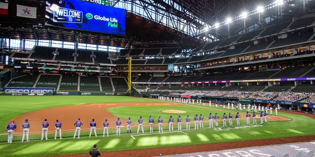 FILE - The Texas Rangers and Colorado Rockies line the foul lines of Globe Life Field before an opening day baseball game in Arlingtn, Texas, in this Friday, July 24, 2020, file photo. (AP Photo/Jeffrey McWhorter, File)