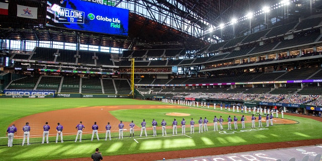 DOSSIER - Les Texas Rangers et les Colorado Rockies alignent les lignes de faute de Globe Life Field avant un match de baseball de la journée d'ouverture à Arlingtn, Texas, en ce vendredi 24 juillet 2020, photo d'archive.  (Photo AP / Jeffrey McWhorter, dossier)