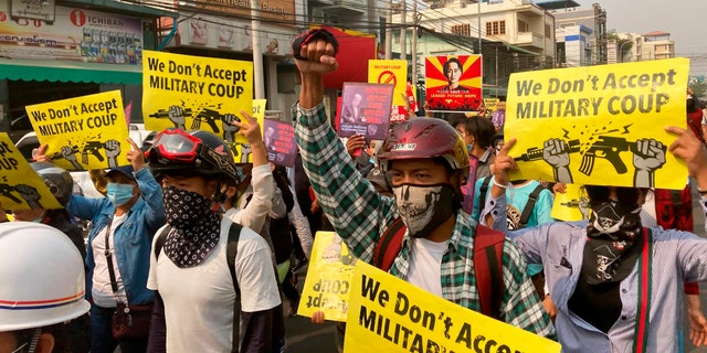 Anti-coup protesters hold signs that read, "We don't accept military coup," during a march in Mandalay, Burma, Sunday, March 14, 2021. The civilian leader of Burma's government in hiding vowed to continue supporting a "revolution" to oust the military that seized power in last month's coup, as security forces again met protesters with lethal forces, killing several people. (AP Photos)