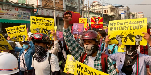 Anti-coup protesters hold signs that read, "We don't accept military coup," during a march in Mandalay, Burma, Sunday, March 14, 2021. The civilian leader of Burma's government in hiding vowed to continue supporting a "revolution" to oust the military that seized power in last month's coup, as security forces again met protesters with lethal forces, killing several people. (AP Photos)