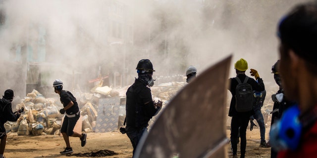 Anti-Coup protesters scatter during the ongoing police crackdown during a protest in Sanchaung township, Yangon, Burma, on Sunday, March 14, 2021. A number of people were shot dead during protests in Burma's largest city on Sunday, as security forces continued their violent crackdown against dissent following last month's military coup. (AP Photo)