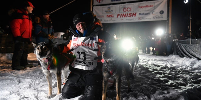 Dallas Seavey poses with his dogs after crossing the finish line to win the Iditarod Trail Sled Dog Race race near Willow, Alaska, early Monday, March 15, 2021. (Marc Lester/Anchorage Daily News via AP, Pool)