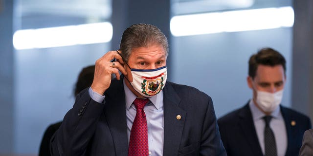 Senator Joe Manchin, DW.Va., adjusts his face mask as he arrives to vote on the candidates for the Biden administration, at the Capitol in Washington, Tuesday, March 16, 2021. 