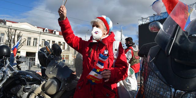 A woman attends the celebration of the anniversary of Crimea annexation from Ukraine in 2014, in Sevastopol, Crimea, Thursday, March 18, 2021.