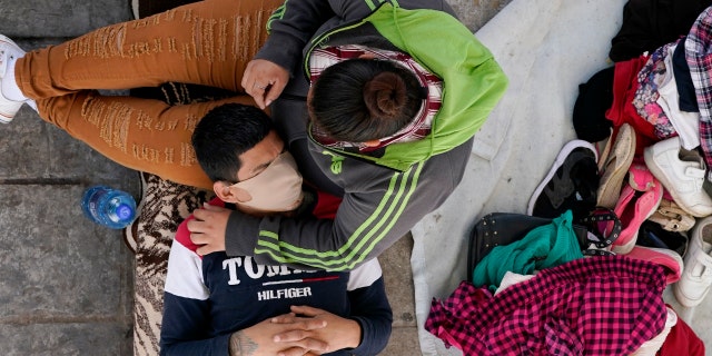 Migrants who were caught trying to sneak into the U.S. and deported rest under a ramp that leads to the McAllen-Hidalgo International Bridge point of entry into the U.S., Thursday, March 18, 2021. (AP Photo/Julio Cortez)