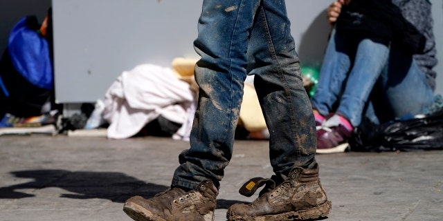 A migrant's muddy shoes are seen without laces as he walks off the customs checkpoint in Reynosa, Mexico, after being deported by U.S. Customs and Border Protection agents. (AP Photo/Julio Cortez)