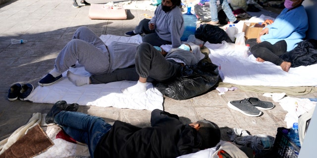 Migrants, who were caught trying to sneak into the U.S. and deported, eat near the McAllen-Hidalgo International Bridge point of entry into the U.S. (AP Photo/Julio Cortez)
