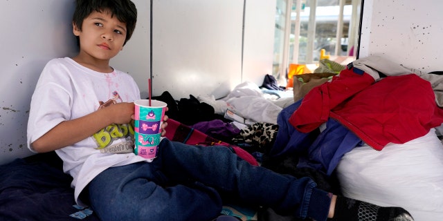 Miguel David Fajardo, 8, a migrant from Honduras, rests at a plaza near the McAllen-Hidalgo International Bridge point of entry into the U.S., after he, his 13-year-old brother and their mother were caught trying to sneak into the U.S. and deported. (AP Photo/Julio Cortez)