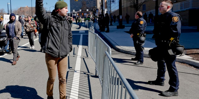 In this March 23, 2019, file photo, a marcher holds up his fist while staring at police lined up in front of PPG Paints Arena in Pittsburgh during a protest after a former suburban police officer was acquitted of a homicide charge in the on-duty shooting death of Antwon Rose II in East Pittsburgh. (AP Photo/Keith Srakocic)