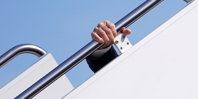 President Joe Biden holds onto the hand rail as he stumbles while boarding Air Force One at Andrews Air Force Base, Md., Friday, March 19, 2021. (AP Photo/Patrick Semansky)