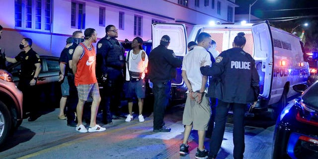 Des policiers de la ville de Miami Beach arrêtent plusieurs hommes sur Ocean Drive et 10th Street alors que les vacances de printemps ont officiellement commencé le samedi 20 février 2021 à Miami Beach, en Floride. 