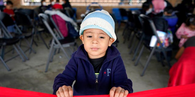 Santiago Lopez Paz, 3, a migrant from Honduras, stands in a respite center hosted by a humanitarian group after he and his family were released from U.S. Customs and Border Protection custody, Saturday, March 20, 2021, in Brownsville, Texas. (AP Photo/Julio Cortez)