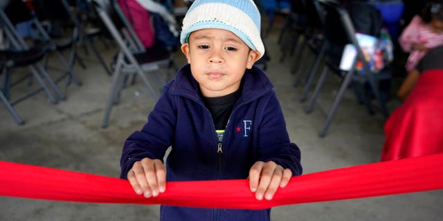 Santiago Lopez Paz, 3, a migrant from Honduras, stands in a respite center hosted by a humanitarian group after he and his family were released from U.S. Customs and Border Protection custody, Saturday, March 20, 2021, in Brownsville, Texas. (AP Photo/Julio Cortez)