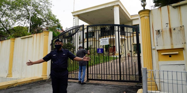 A staff locks the front gate of North Korean embassy in Kuala Lumpur, on Sunday. Malaysia on Friday ordered all North Korean diplomats to leave the country within 48 hours, an escalation of a diplomatic spat over Malaysia's move to extradite a North Korean suspect to the United States on money laundering charges. (AP Photo/Vincent Thian)