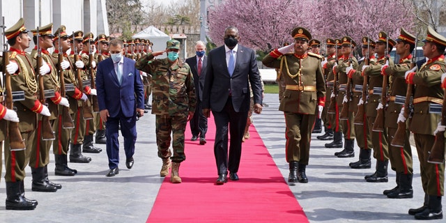 ADDS REFERENCE TO ACTING AFGHAN MINISTER OF DEFENSE YASIN ZIA - U.S. Defense Secretary Lloyd Austin, center, walks on the red carpet with Acting Afghan Minister of Defense Yasin Zia as they review an honor guard at the presidential palace in Kabul, Afghanistan, Sunday, March 21, 2021. Austin arrived in Kabul on his first trip to Afghanistan as Pentagon chief, amid swirling questions about how long American troops will remain in the country. (Presidential Palace via AP)