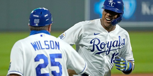 In this Thursday, Sept. 24, 2020 photo, Kansas City Royals' Salvador Perez celebrates with third base coach Vance Wilson after hitting a three-run home run during the first inning of the team's baseball game against the Detroit Tigers in Kansas City, Mo. (AP Photo/Charlie Riedel, File)